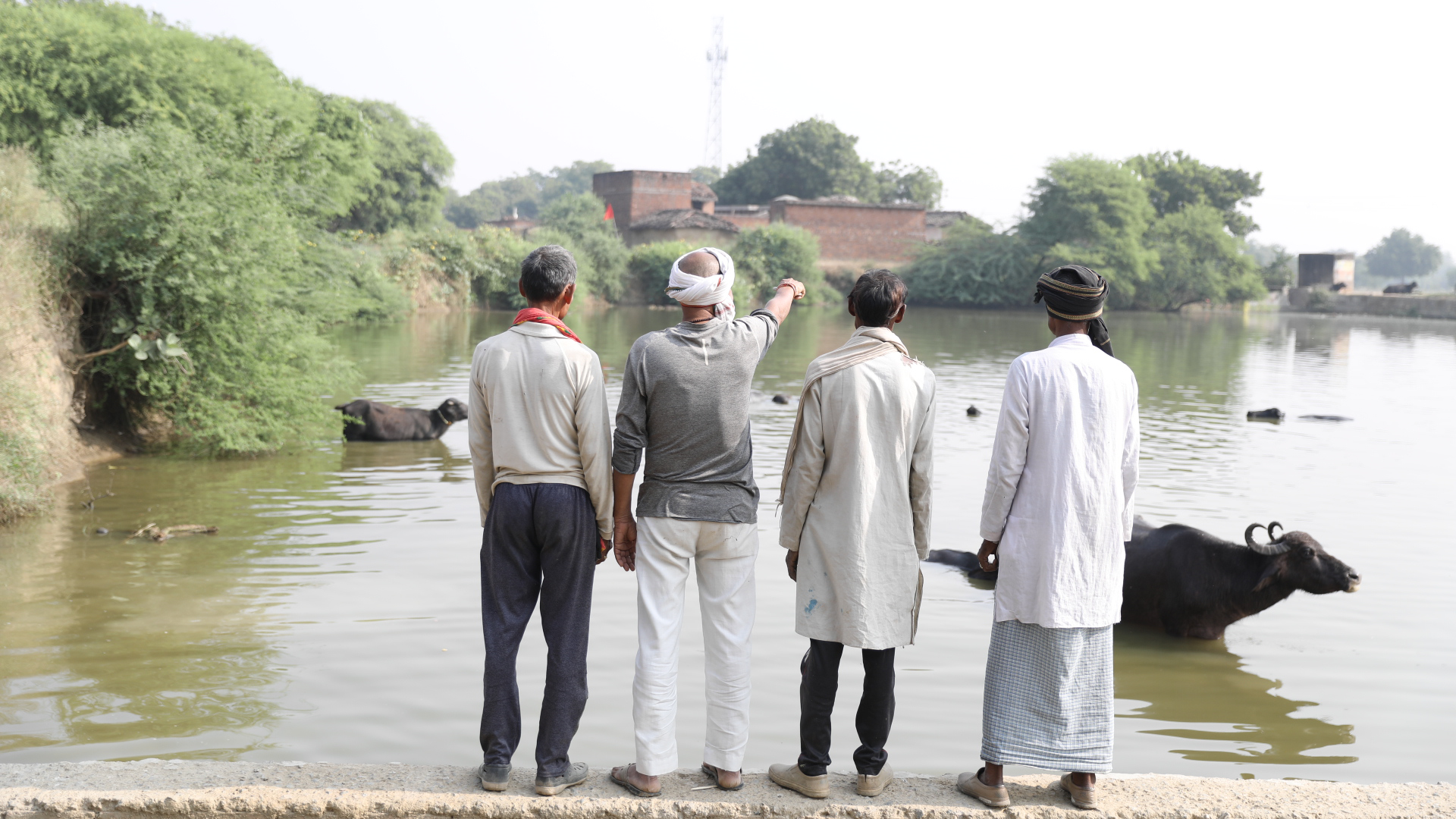 a picture of farmers looking at a checkdam filled with water