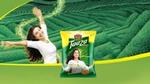 A woman waving her arms around in a tea field, with a packshot at the front