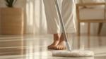 A woman mops the floor, focusing on cleaning a section of the surface with a mop in her hands.