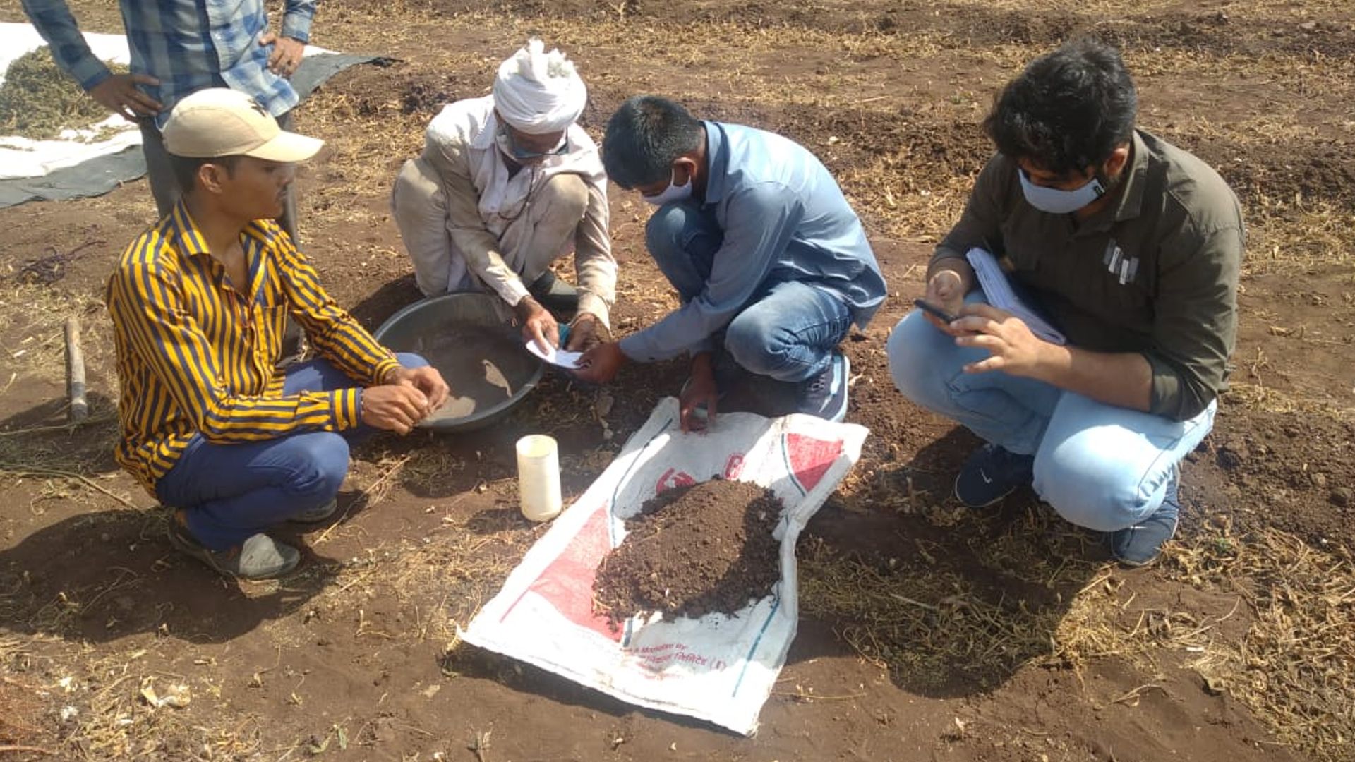 A pic where samples of soil are being collected from the field