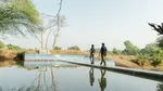 Two men at a water reservoir.