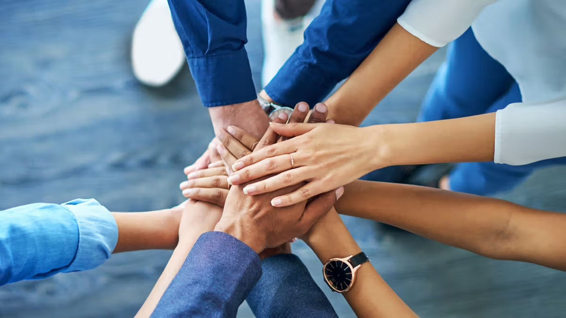 Group of hands stacked together symbolizing teamwork