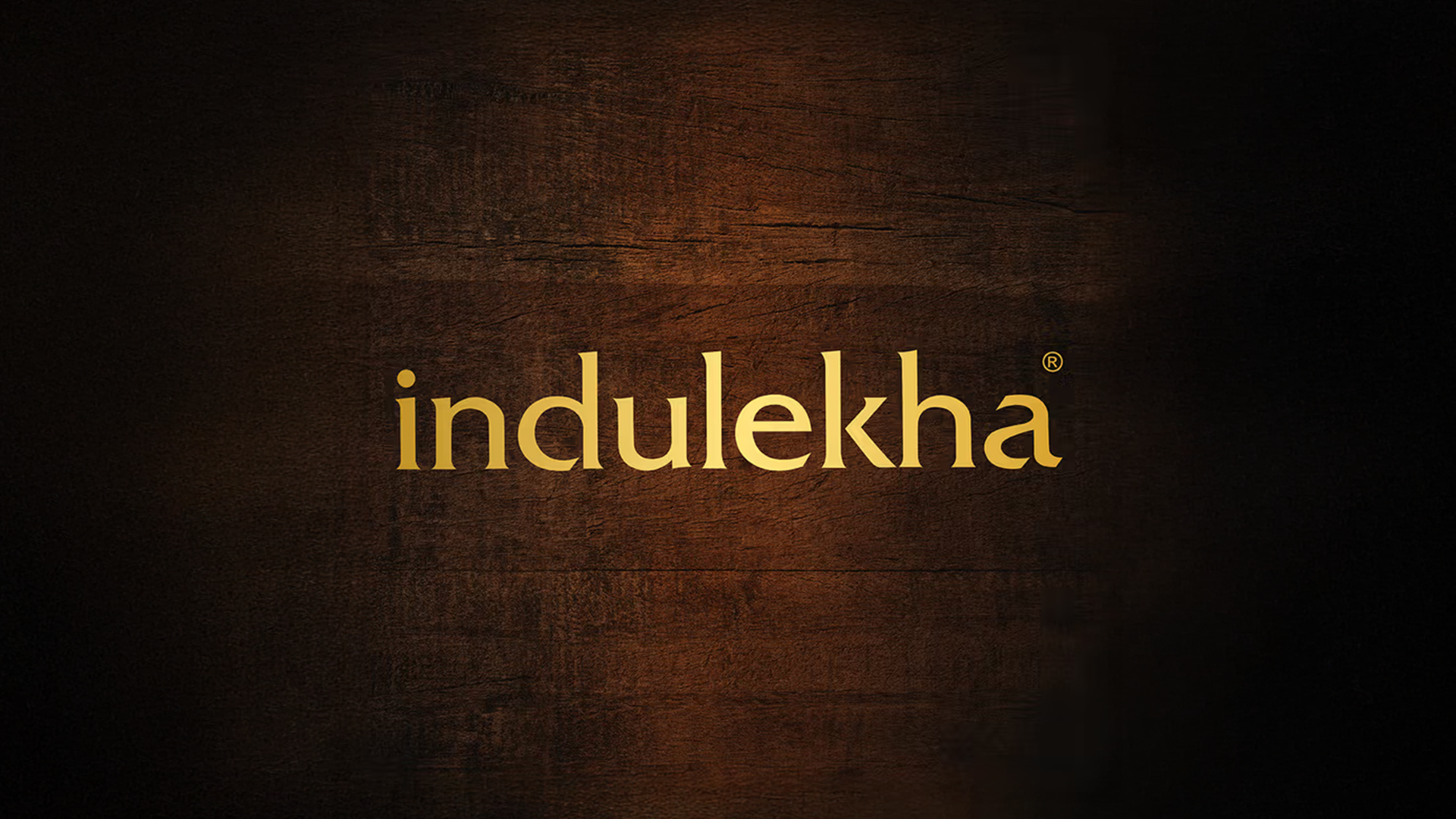 Indulekha logo with brown wood background