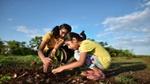 Two girls planting a plant