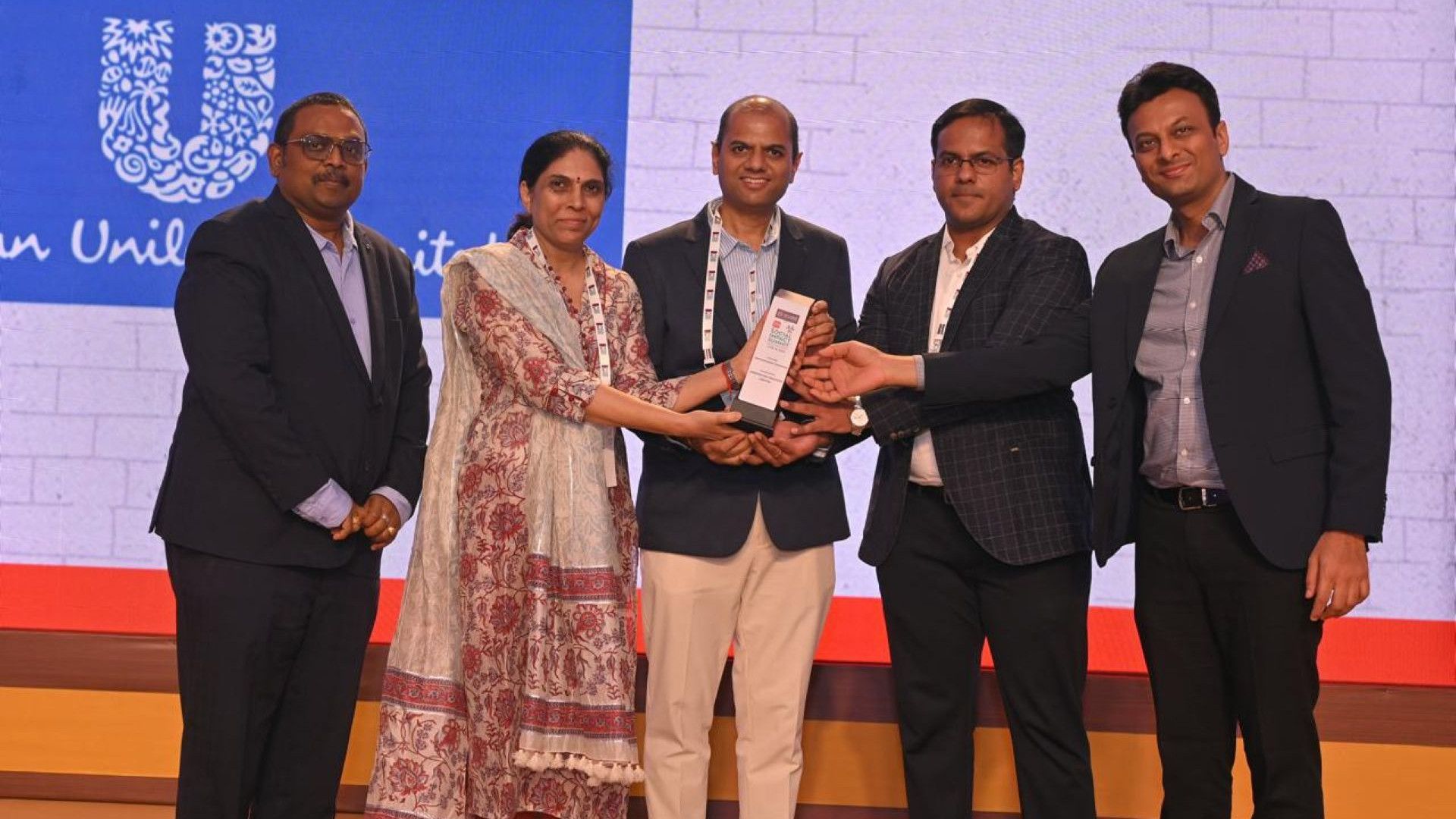 A group of five people with the Times of India Social Impact award.