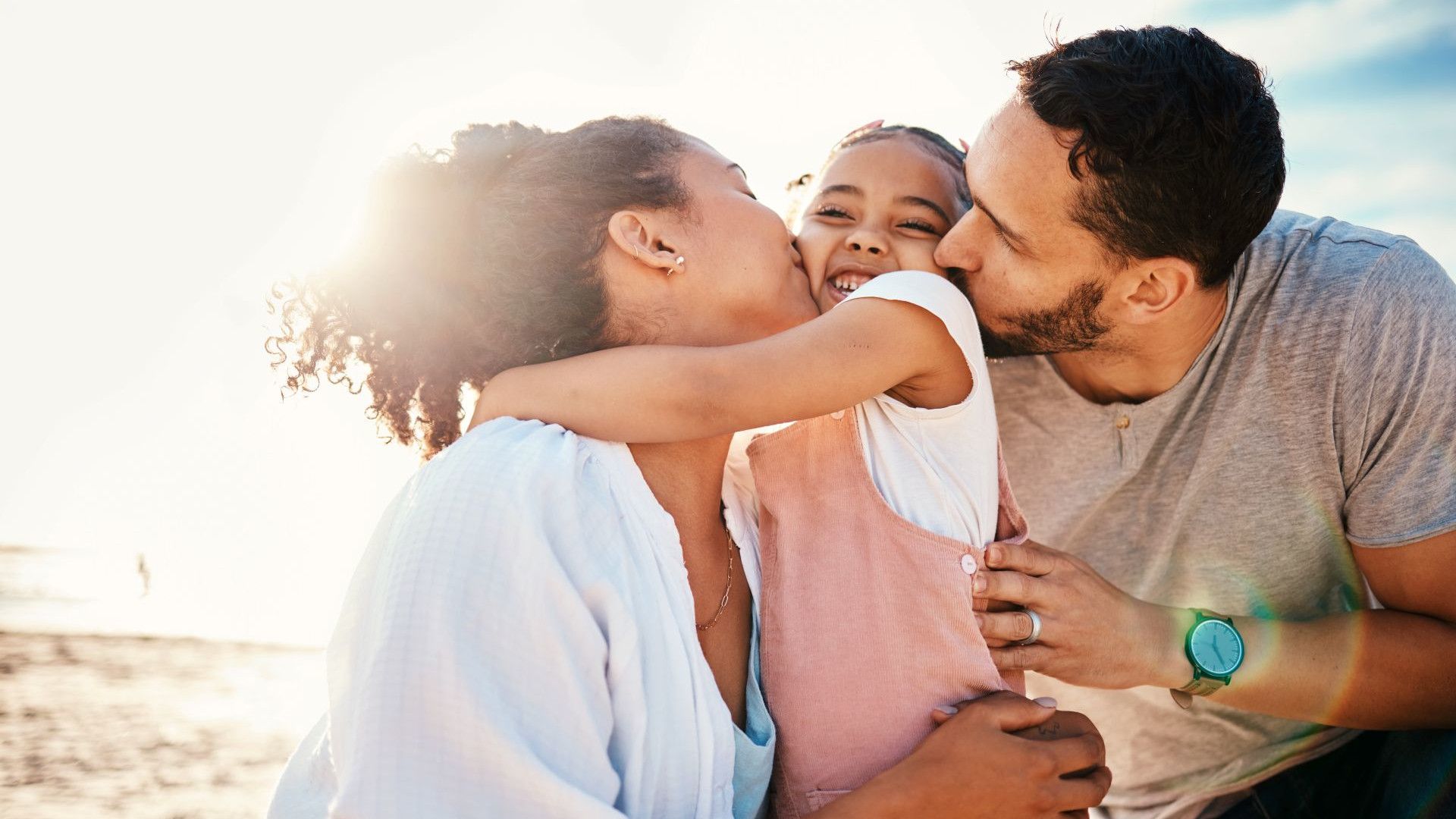 A happy family of three at the beach.