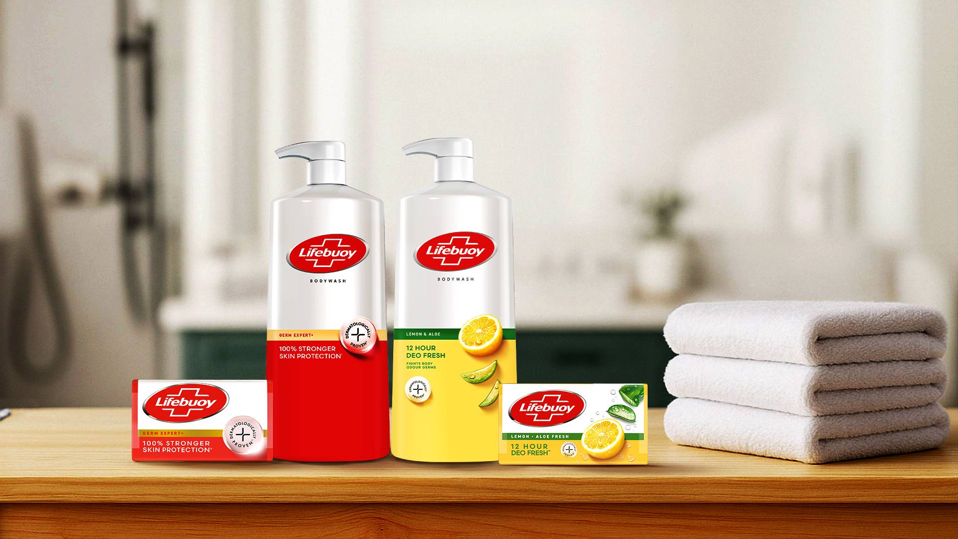Lifebuoy body wash and soap bars with folded towels on a wooden surface