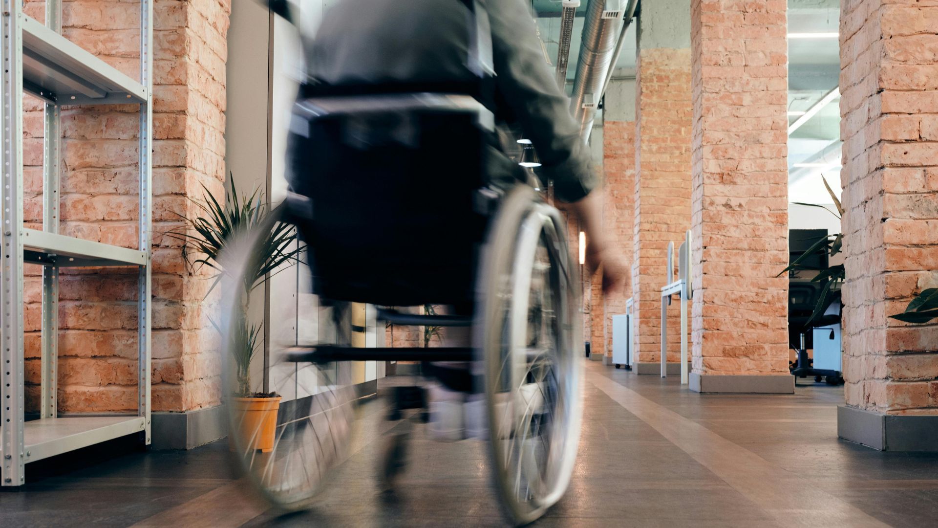 A picture of a person with disability on a wheelchair in an office set up.