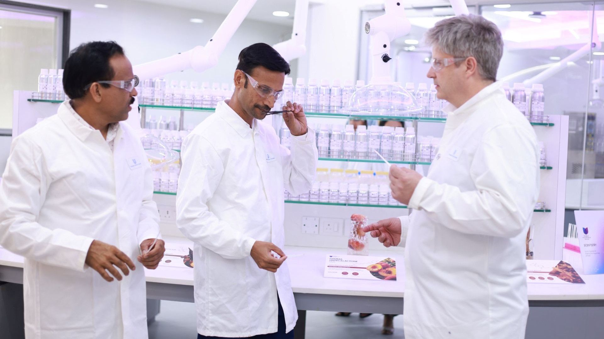 Three perfumers in white lab coats testing fragrances at Unilever’s new Fragrance House hub in Mumbai, India.