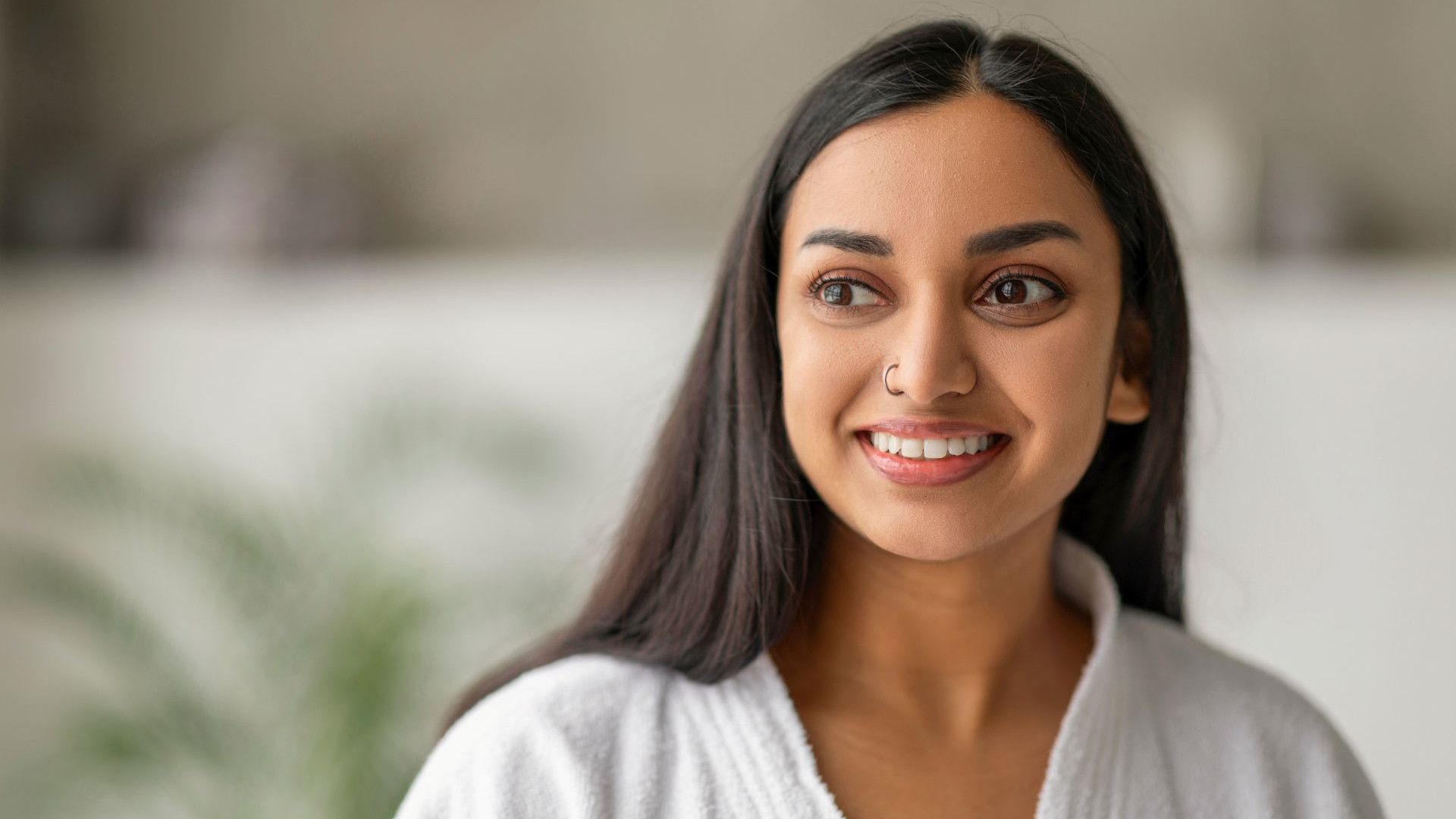 A smiling woman in a white robe.