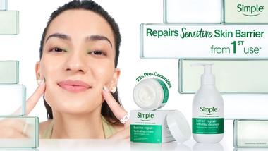 Woman applies Simple barrier repair cream beside a bottle of hydrating cleanser.