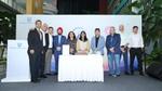 Corporate leaders stand behind a table with a cake at a Hindustan Unilever event.