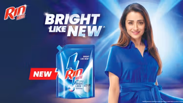 Rin Matic ad showing a woman in a bright blue dress and a detergent pack with the tagline "Bright Like New."
