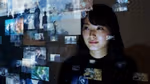 Asian woman viewing many screens of information floating in front of her