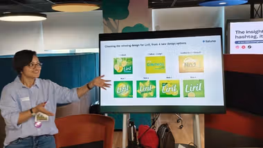 Person presenting Liril soap packaging design options on screen.