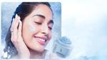 Smiling woman applies Pond’s Biome Miracle freeze recovery gel to her cheek beside the featured product jar.