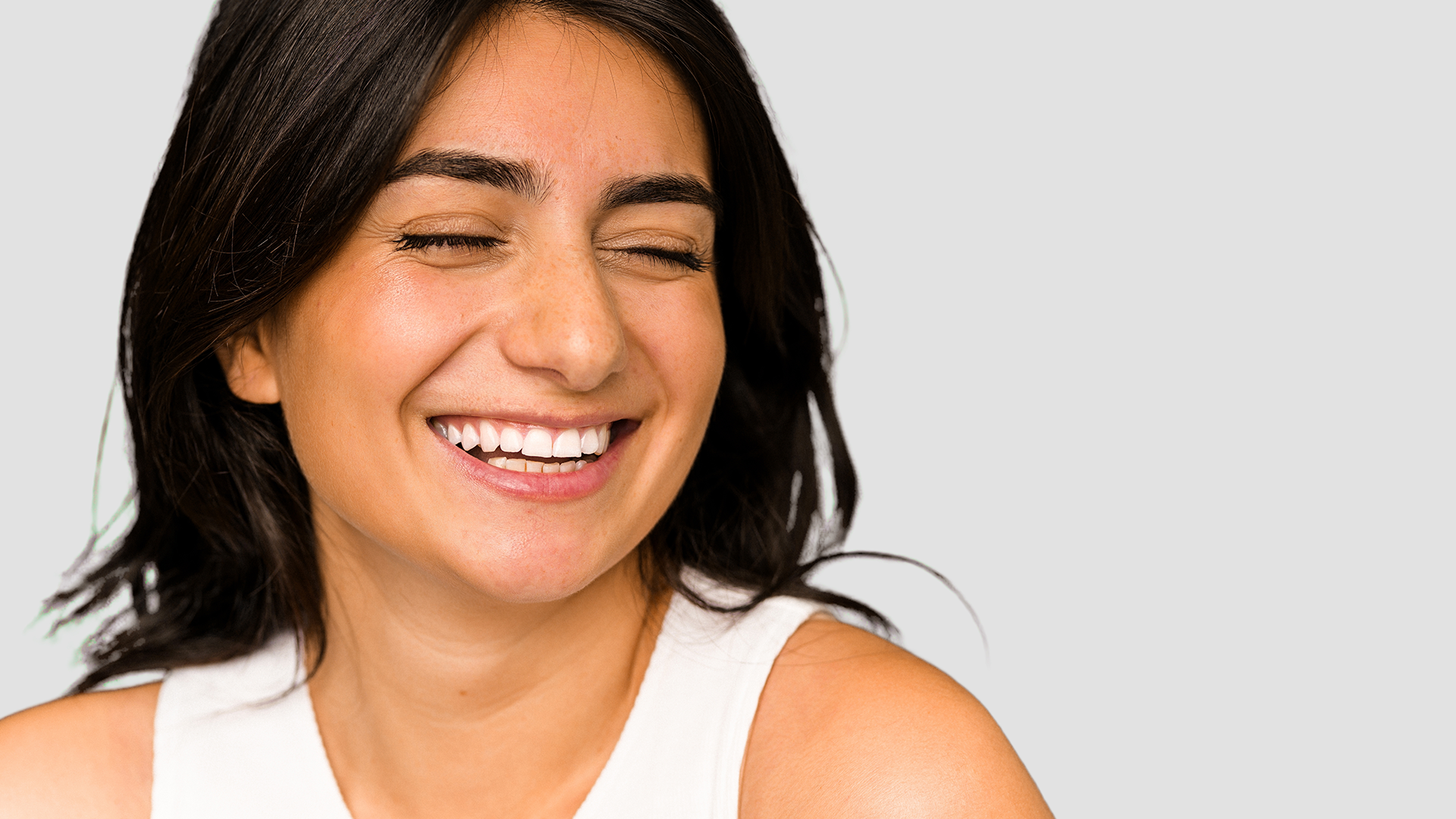 a woman wearing a white vest smiling