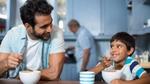 A man and a child have breakfast at home.