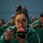 A woman wearing the Squid Game outfit eats a bowl of Knorr Korean Ramen.