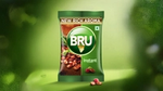 BRU Instant coffee pack with rich aroma, green packaging, and coffee beans on a soft green background.