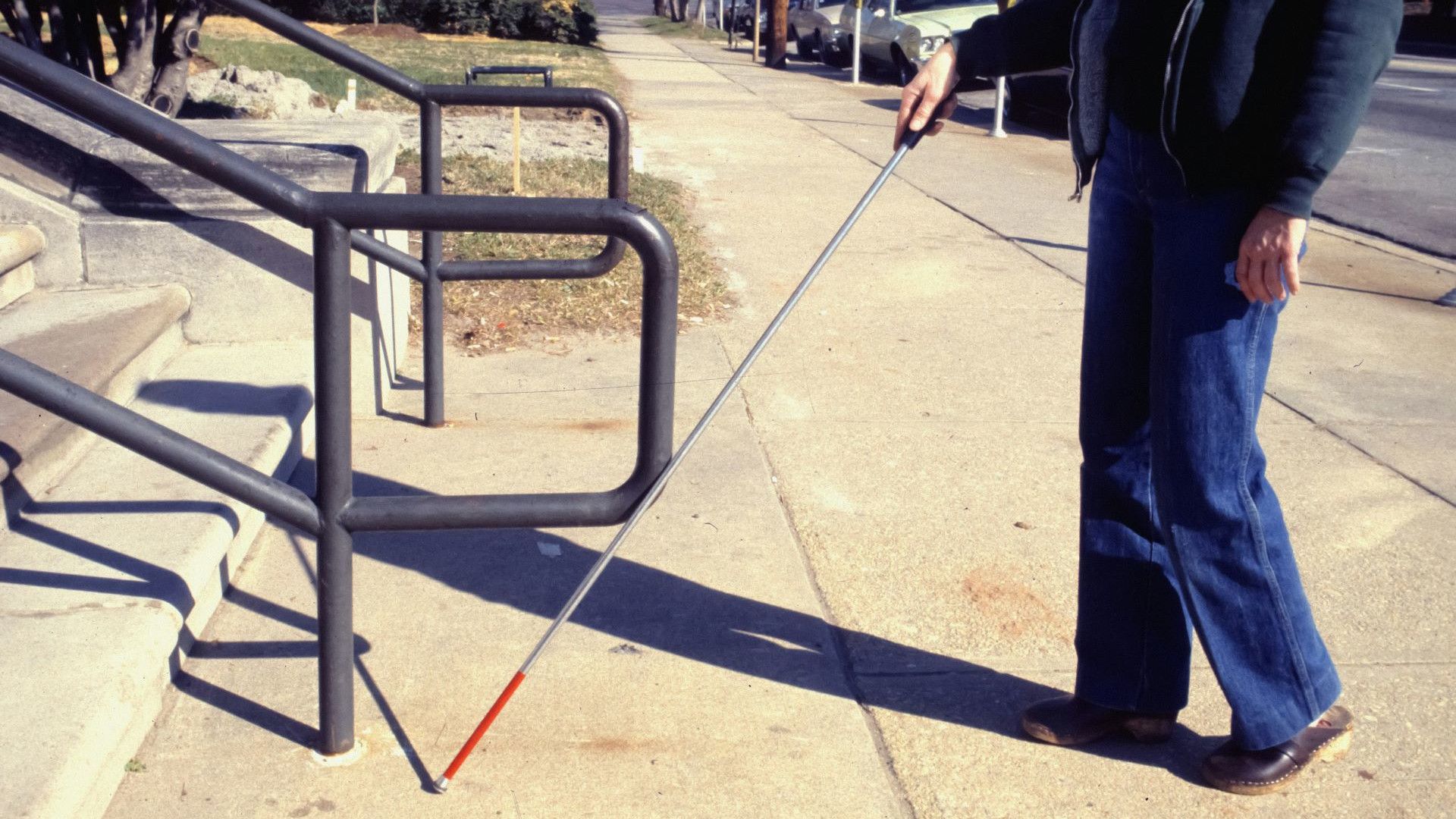 A man walking with the help of a cane.
