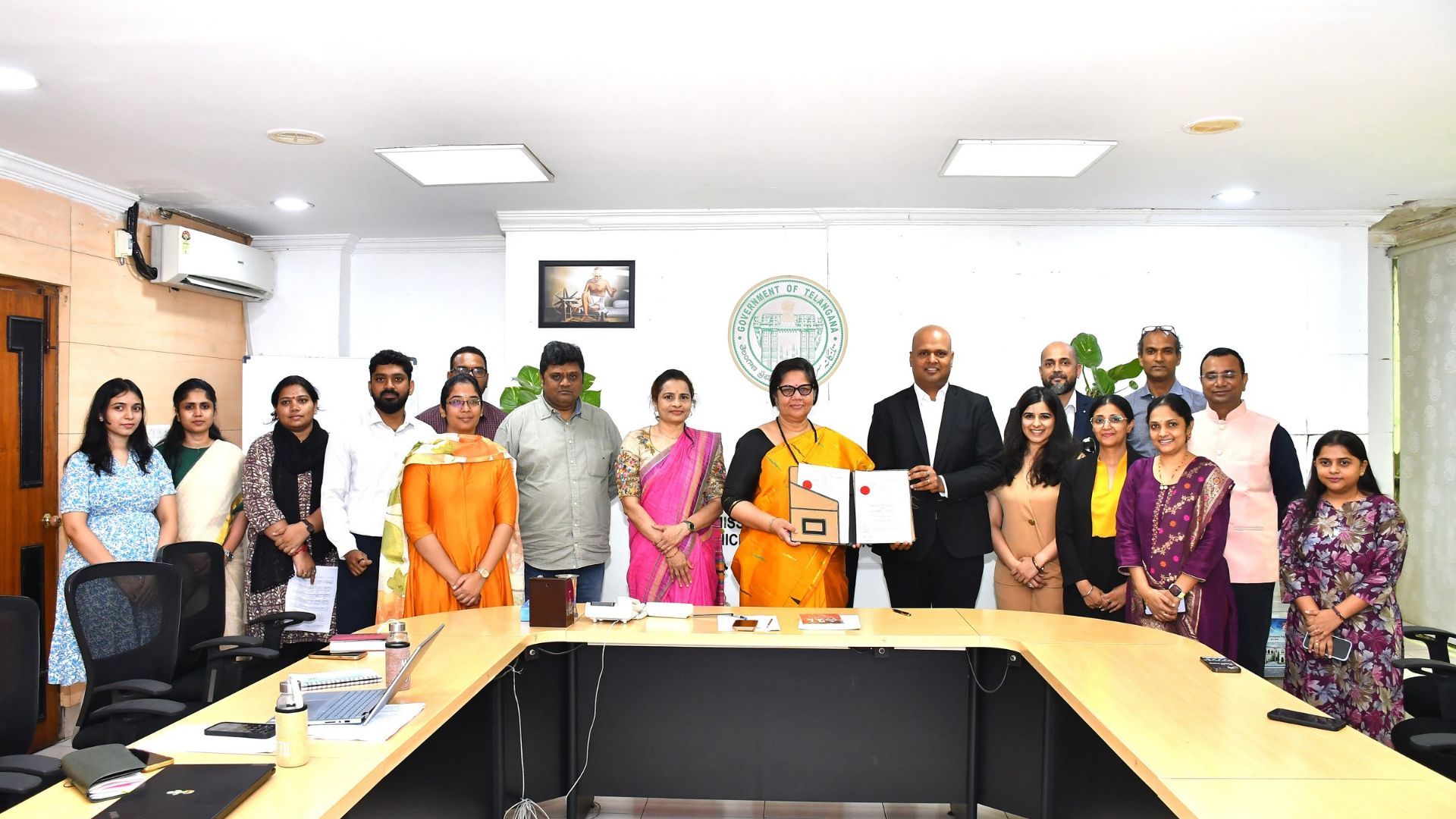 Officials pose with a signed agreement at a Government of Telangana office.
