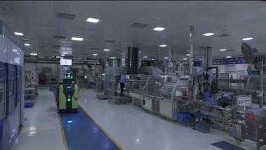 Automated factory with machinery and robotic vehicle in operation.