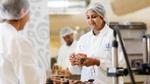 Image of a female HUL employee working at a HUL facility. She appears to be smiling.