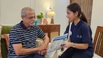 A volunteer showing paper and talking to an elderly man