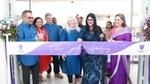 Group of people cutting a ribbon at an event, standing behind a banner that reads “Future Smells Amazing”.