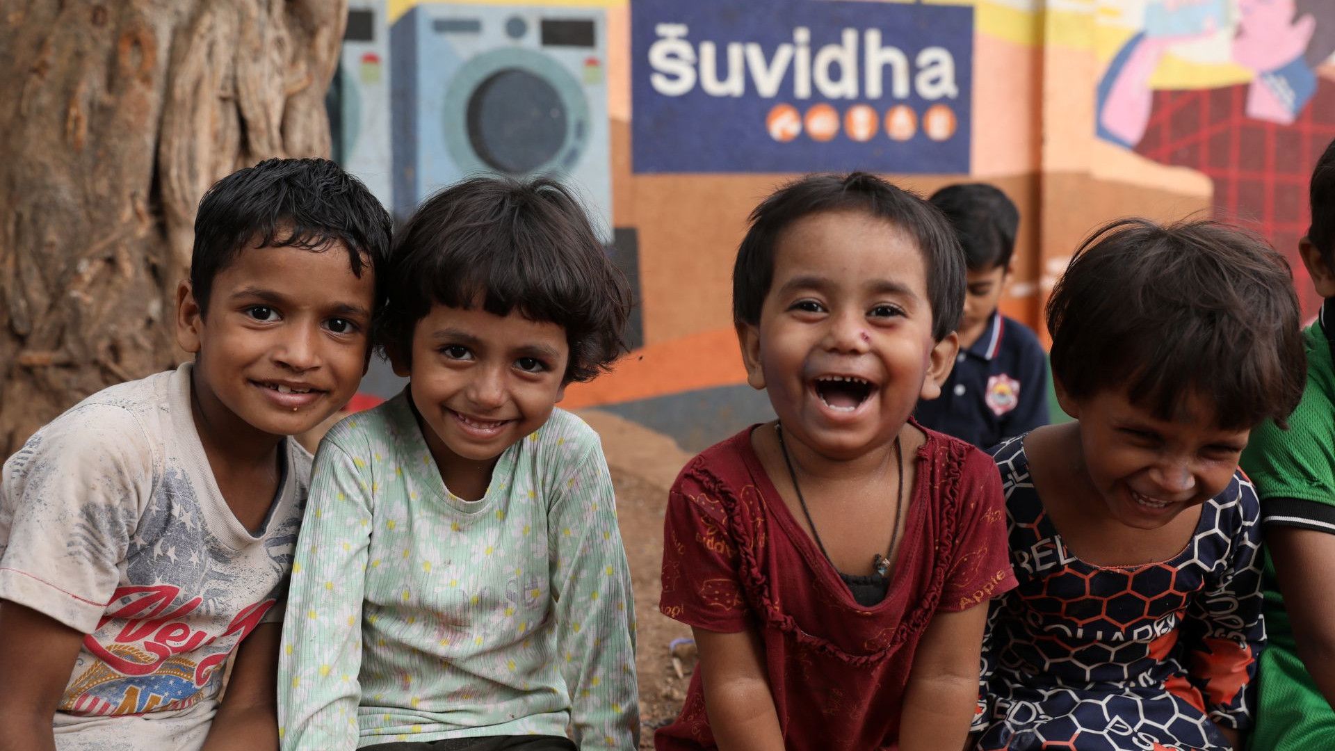 A group of four happy Indian children.