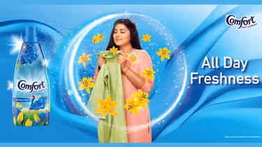 Image of a woman smelling her clothes after being washed with Comfort - All day freshness.