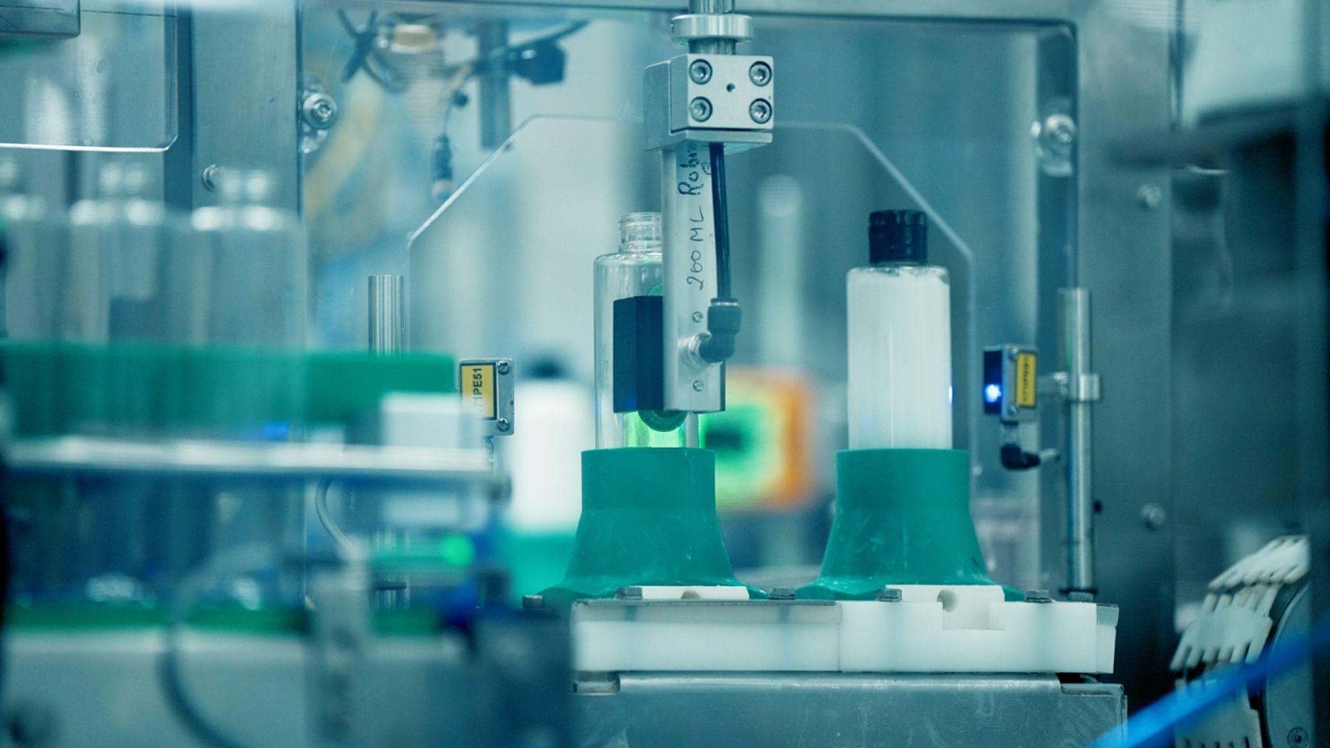 Automated factory machine filling plastic bottles on a production line