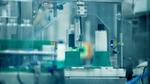Automated factory machine filling plastic bottles on a production line
