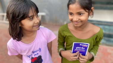 Two little girls smiling at each other