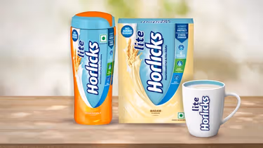 Horlicks Lite nutrition drink in regular malt and badam flavours, along with a branded white mug with Horlicks Lite is shown filled with the drink.
