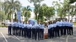 A team of employees standing together outdoors, posing for a group photo.