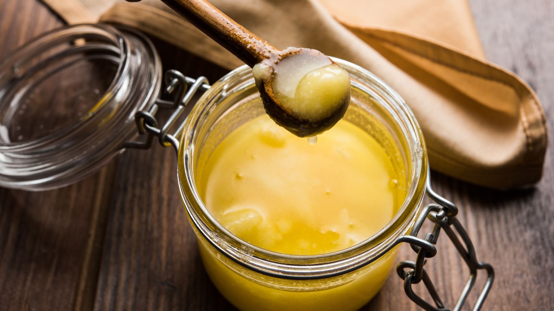 A jar of clarified butter and a wooden spoon