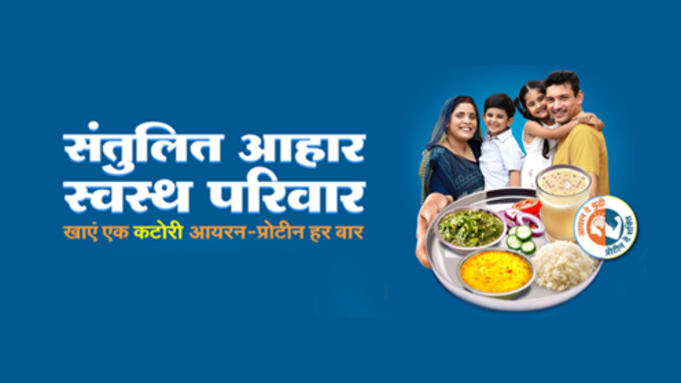 An indian family posing while holding a plate of food
