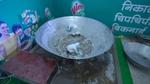 Two people washing up the cauldron where halwa was cooked in.