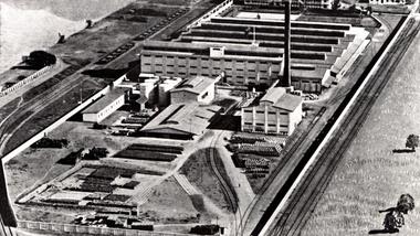 Historic aerial view of a large industrial factory complex beside railway tracks