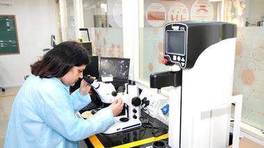 A scientist looking through a microscope