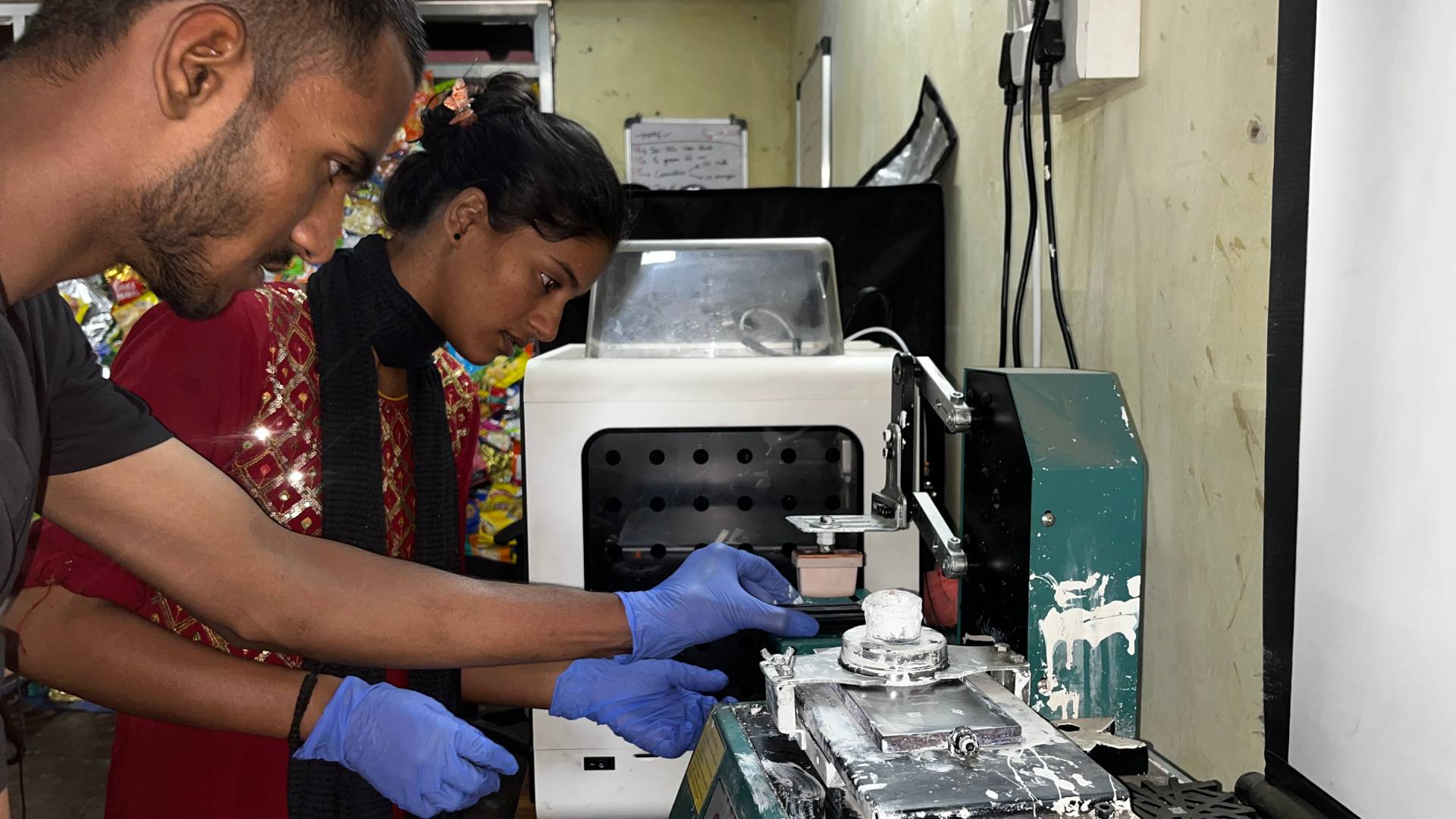 Two workers lifting a pile of plastic segregated waste